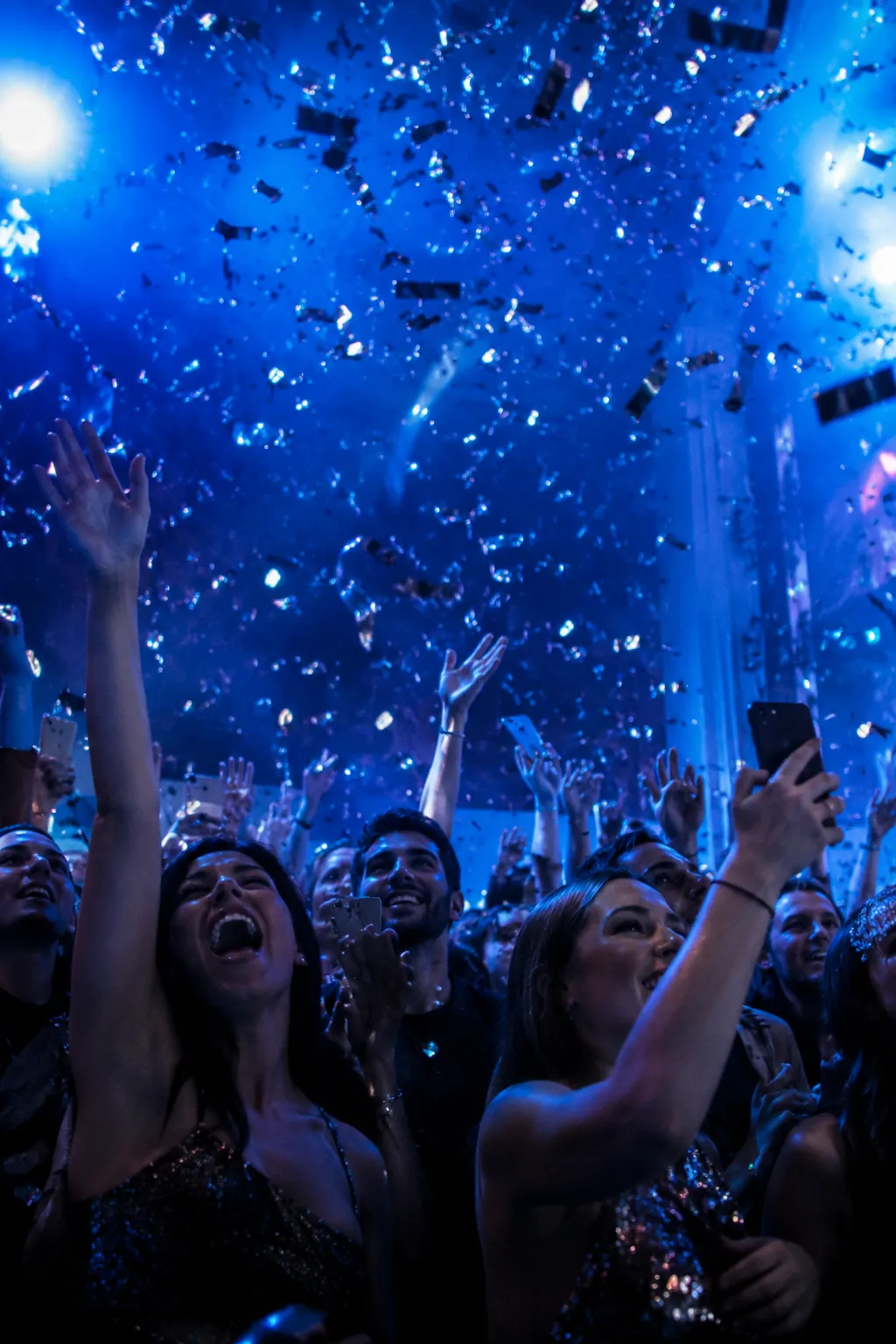 Guests cheering under cobalt light at a previous launch, fictional sample photograph